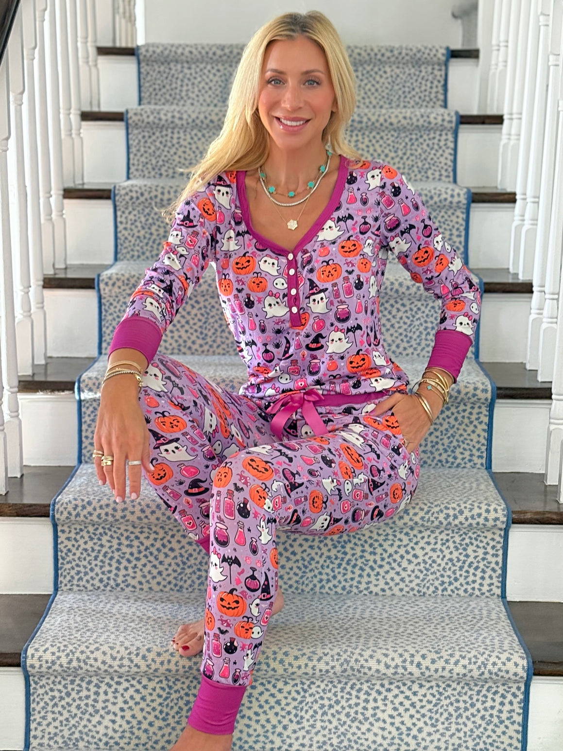 Jordann sitting on a staircase wearing the Hocus Pocus Ghost Jogger Pajama Set.