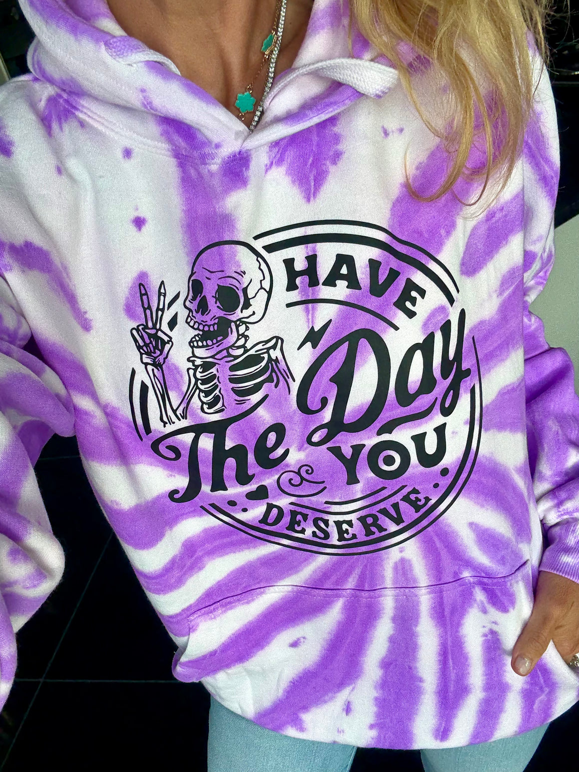 Purple and white tie-dye hoodie with skeleton graphic and text