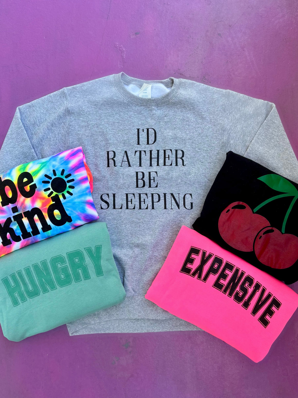 Collection of sweatshirts with text on a purple background