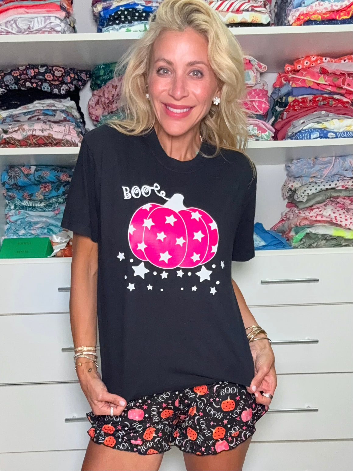 Woman wearing a black t-shirt with a pink pumpkin design.