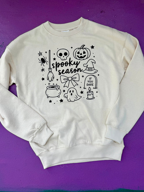 White sweatshirt with Halloween-themed graphics on a purple background